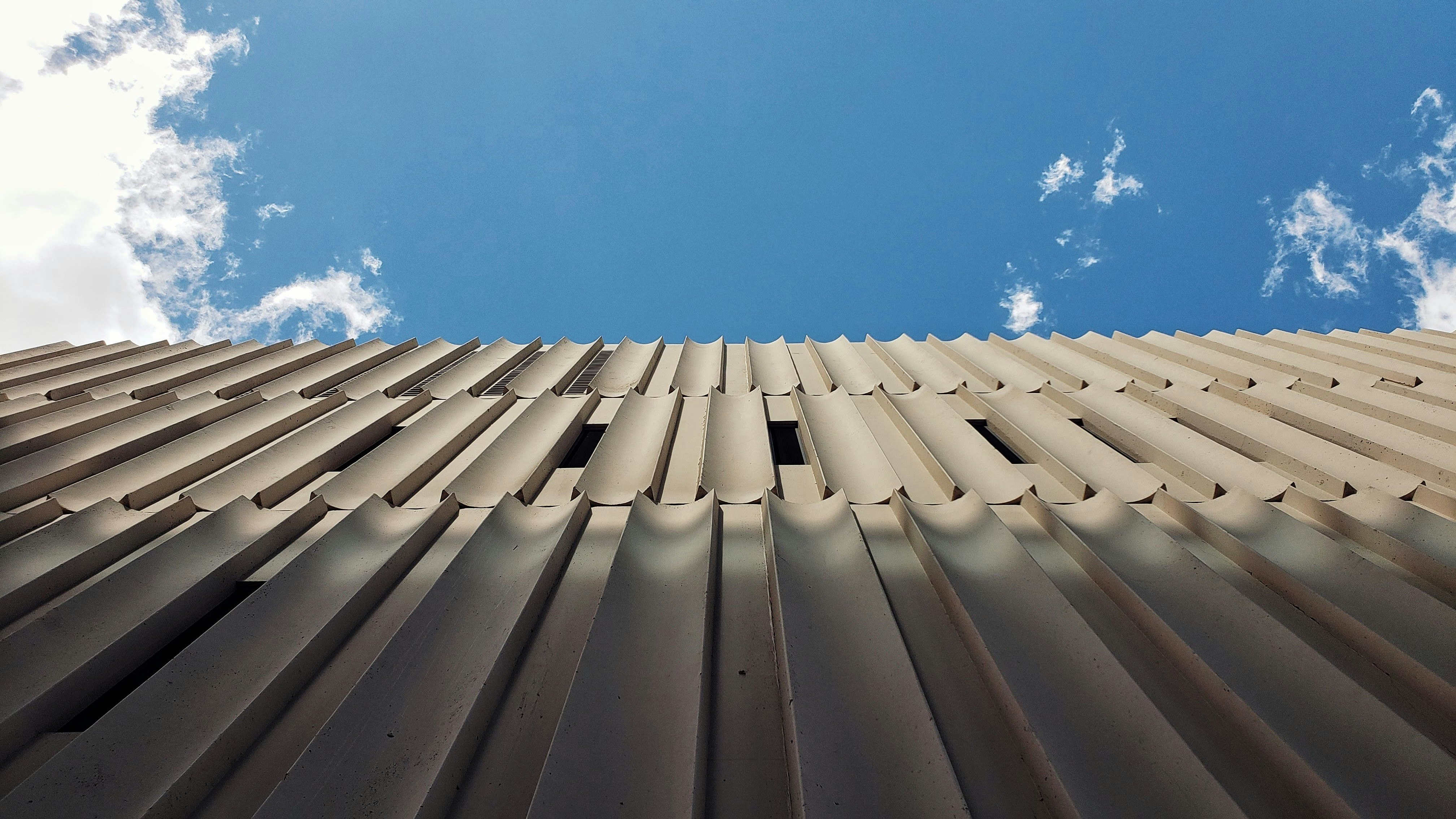 low angle photography of beige concrete building during daytime